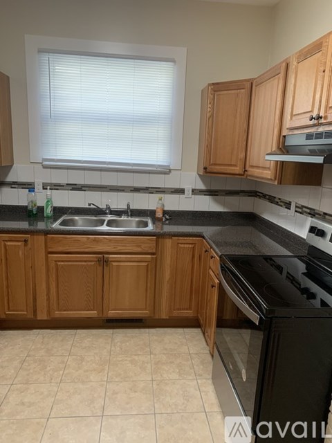 A kitchen with wooden cabinets and black appliances.