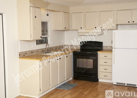 A kitchen with white cabinets and a black oven.