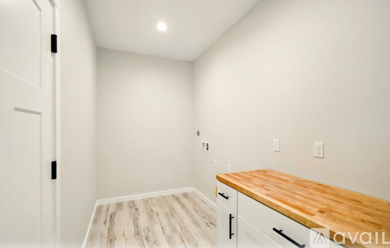 A kitchen with white cabinets and a wooden countertop.