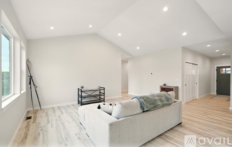 A spacious bedroom with a large bed and wooden flooring.