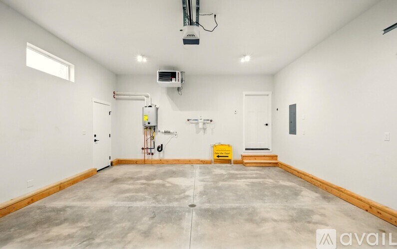 A large empty room with a concrete floor and white walls.
