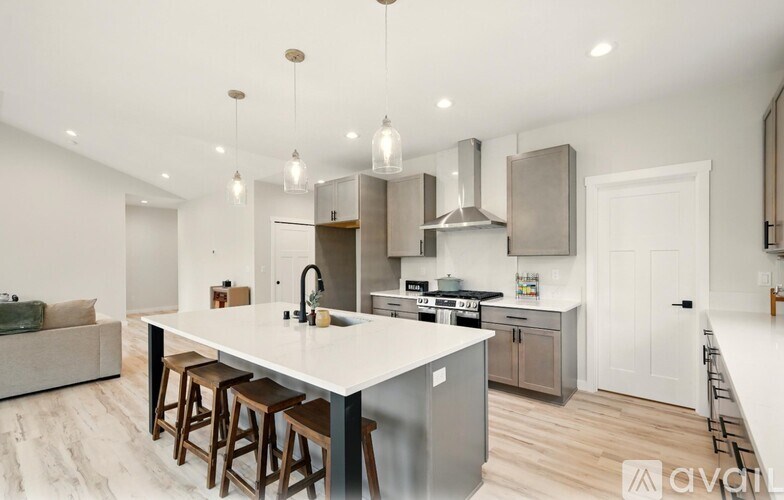 A modern kitchen with a large island and stainless steel appliances.