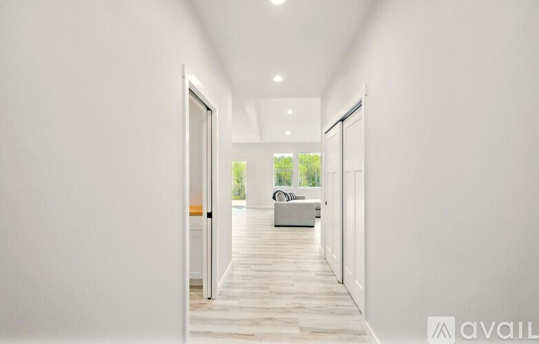 A long hallway with a door on the left and a balcony on the right.