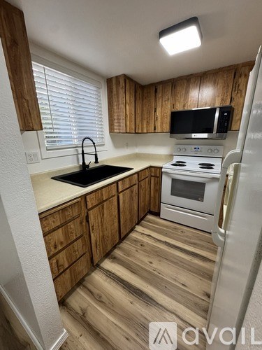 A kitchen with wooden cabinets and a white fridge.