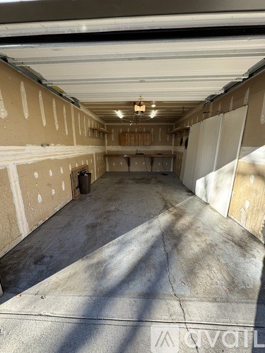 The image shows an unfinished room with exposed ceiling and walls.