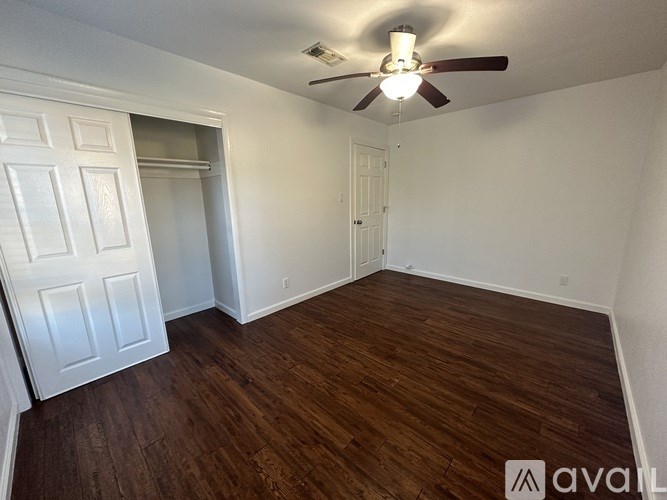 A room with wooden flooring and a ceiling fan.