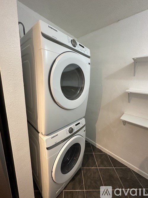 A stack of three Samsung front loading washing machines in a laundry room.