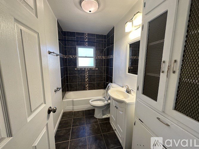 A bathroom with a white toilet, sink, and bathtub.