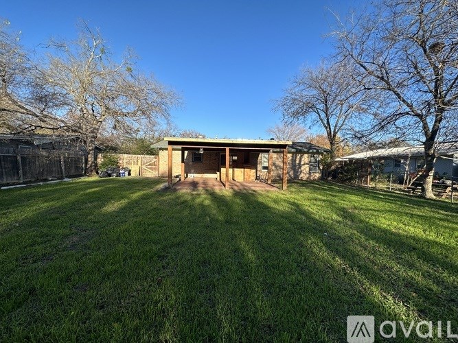 A backyard with a shed and a fence.