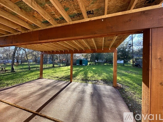A wooden covered patio with a roof and walls.