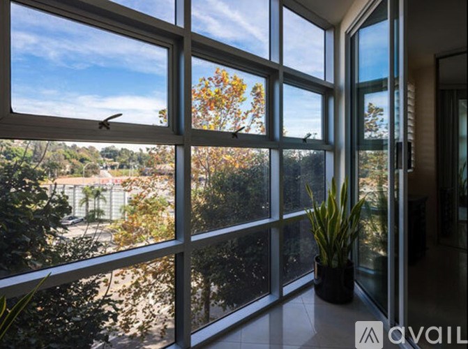 A room with a large window overlooking a tree-filled landscape.