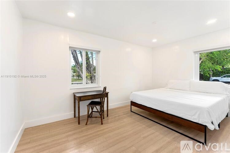 A bedroom with a bed, desk, and chair.