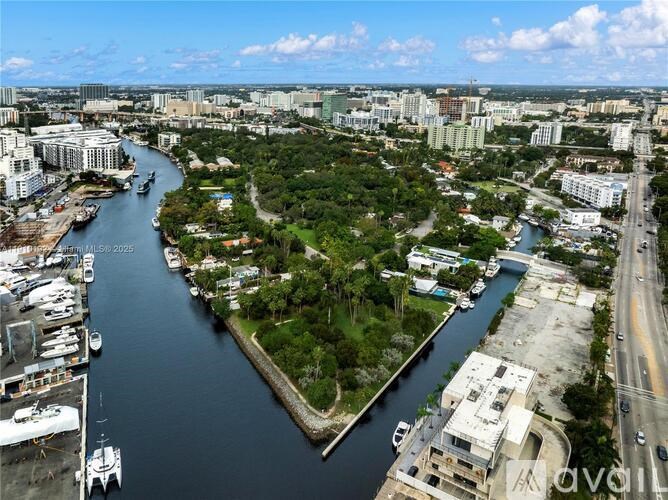 A river flows through a city with a green island in the middle.