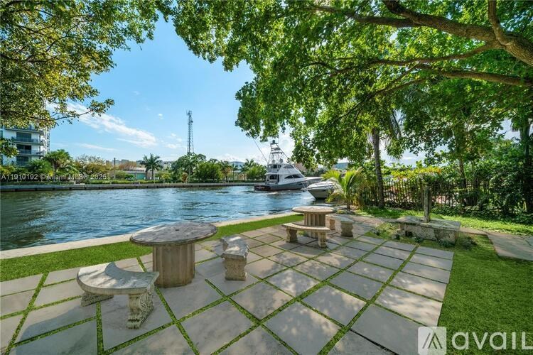A patio with a table and chairs overlooking a body of water.