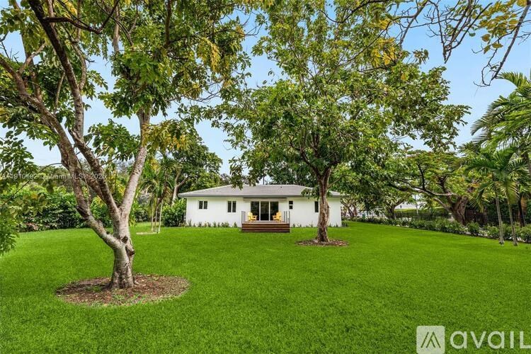 A white house with a tree in front of it.