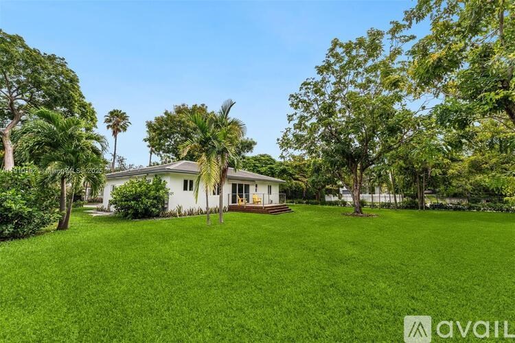 A house with a lawn and trees in front of it.