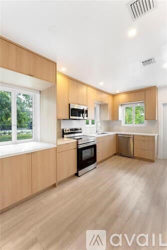 A kitchen with wooden cabinets and a window.