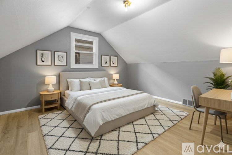 A bedroom with a large bed and a desk.