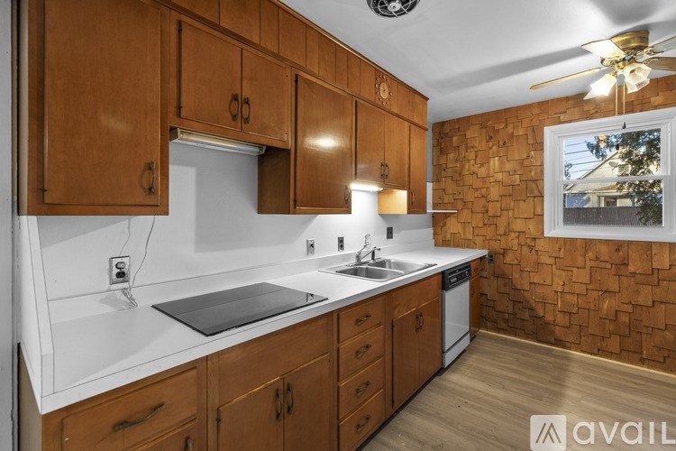 A kitchen with wooden cabinets and a brick wall.