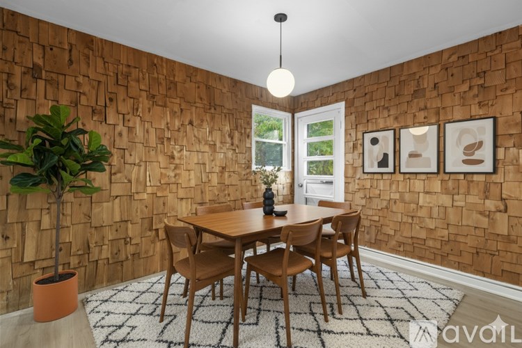 A dining room with a wooden table and chairs.