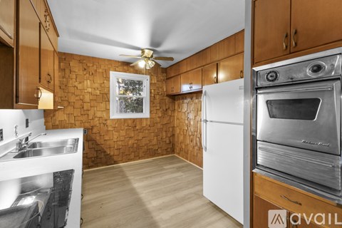 A kitchen with wooden cabinets and a white fridge.