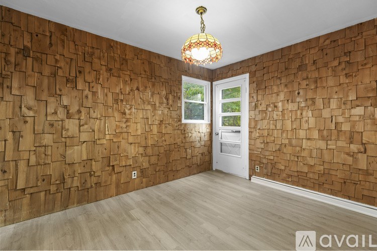 A room with wooden wall paneling and a white door.
