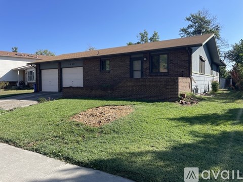 A house with a brown roof and a white garage door.