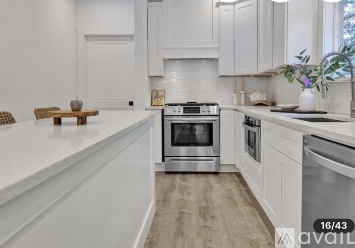 A modern kitchen with a white countertop and a stainless steel oven.