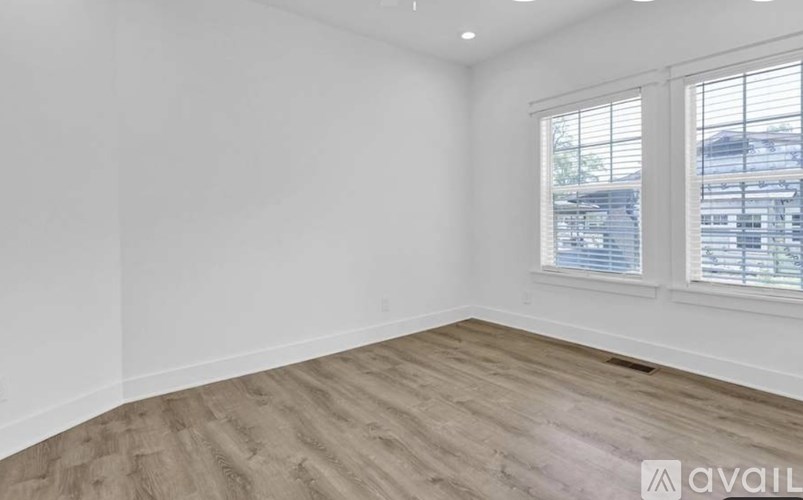 A room with a window and wooden flooring is available for rent.