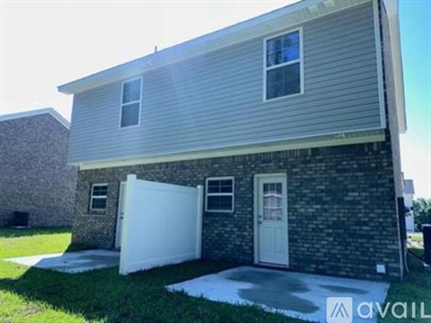 A house with a white garage door and a brick wall.