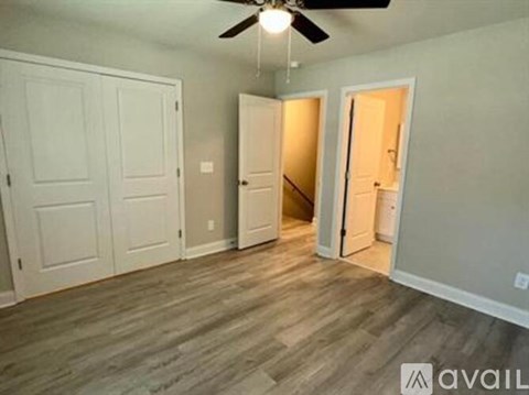 A room with a ceiling fan and wooden flooring.