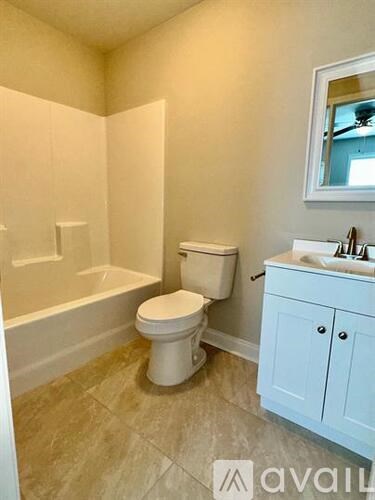 A white toilet sits in a bathroom next to a sink.