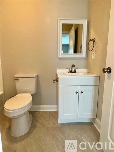 A white toilet sits next to a sink in a bathroom.