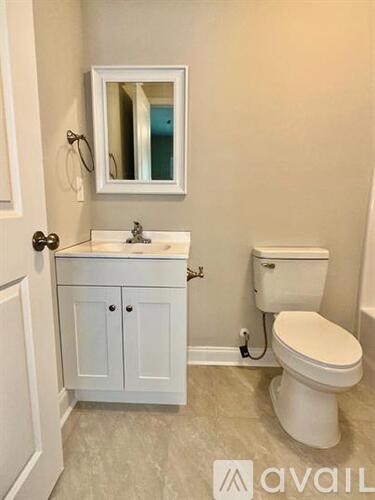 A white toilet sits next to a sink in a bathroom.