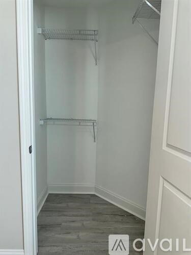 A white closet with a grey carpet and a door.