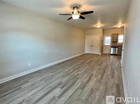 A room with a ceiling fan and wooden flooring.