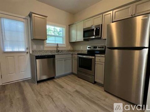 A kitchen with a stainless steel refrigerator, oven, and microwave.