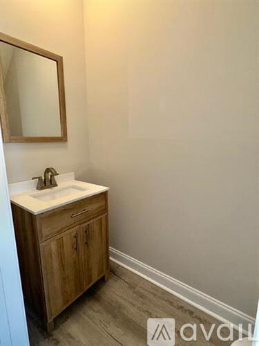 A bathroom with a wooden cabinet and a sink.