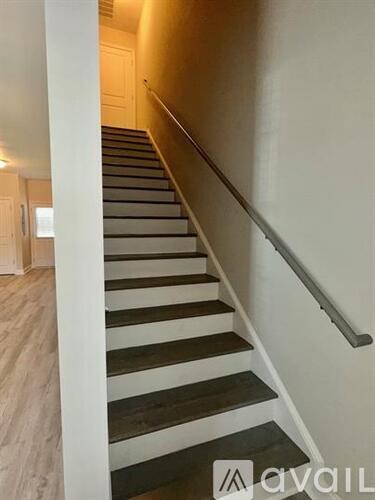 A staircase with wooden steps and a metal handrail.