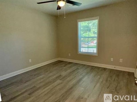 A room with a ceiling fan and a window.