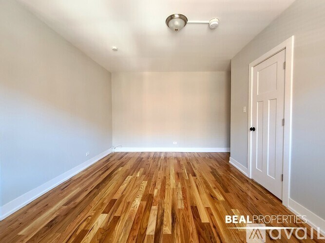 A room with wooden flooring and a white door is available for rent.