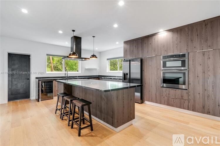 A modern kitchen with wooden cabinets and a central island.