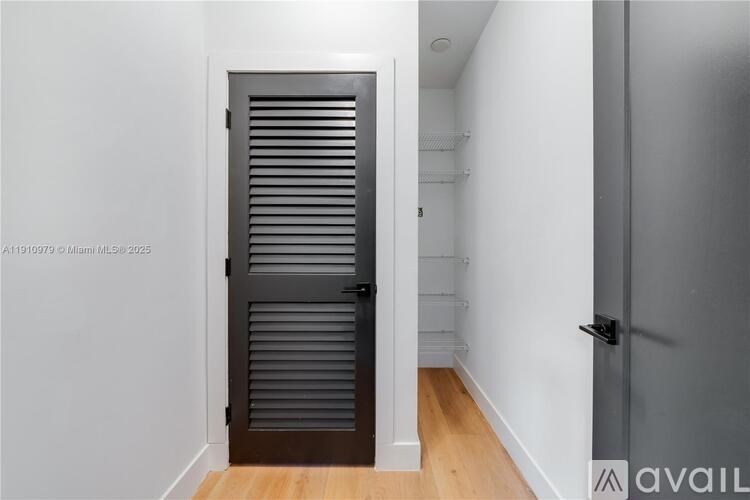 A hallway with a closed door and a wooden floor.