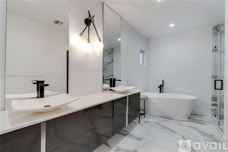 A modern bathroom with a white sink and a bathtub.