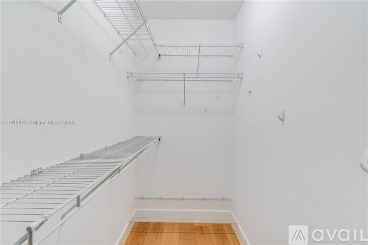 Empty white room with shelves and wooden floor.