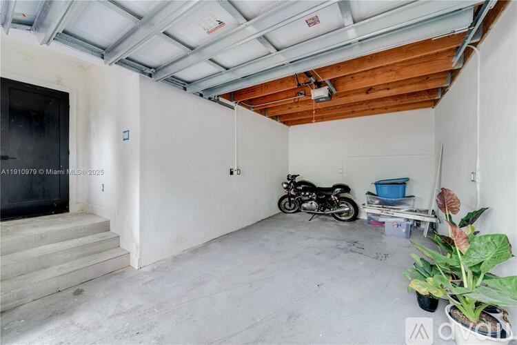 A motorcycle is parked in a room with a wooden ceiling and a concrete floor.
