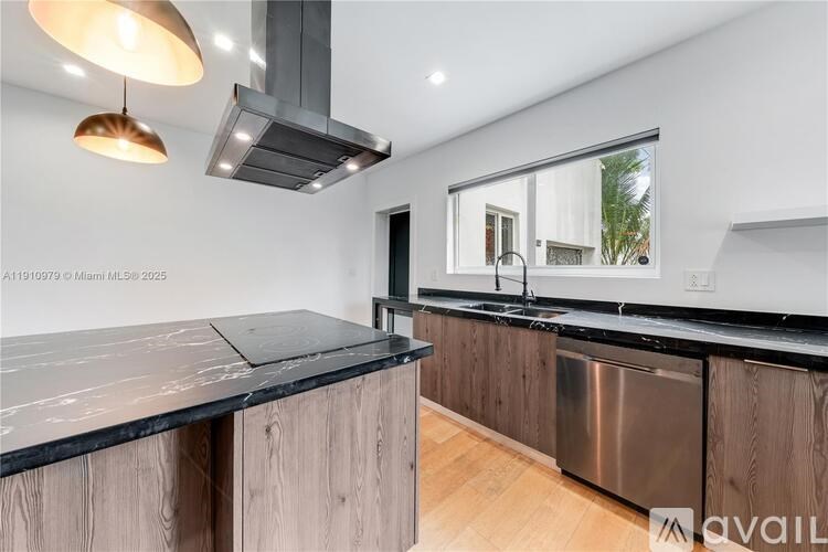 A modern kitchen with a large island and stainless steel appliances.