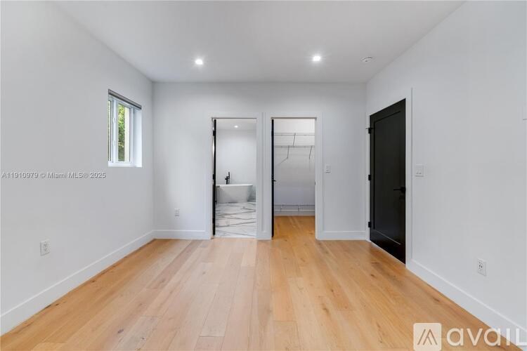 A spacious room with wooden flooring and white walls, currently under renovation.