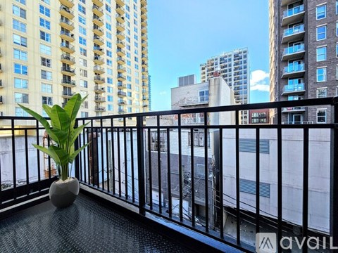 A balcony with a potted plant and a view of a cityscape.