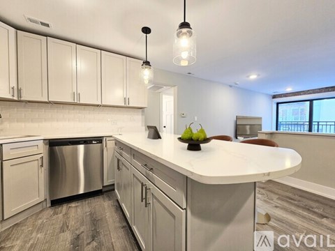 A modern kitchen with a large island and stainless steel appliances.